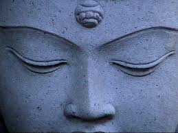 Here's an alt tag for the image: Serene stone Buddha face, eyes closed.